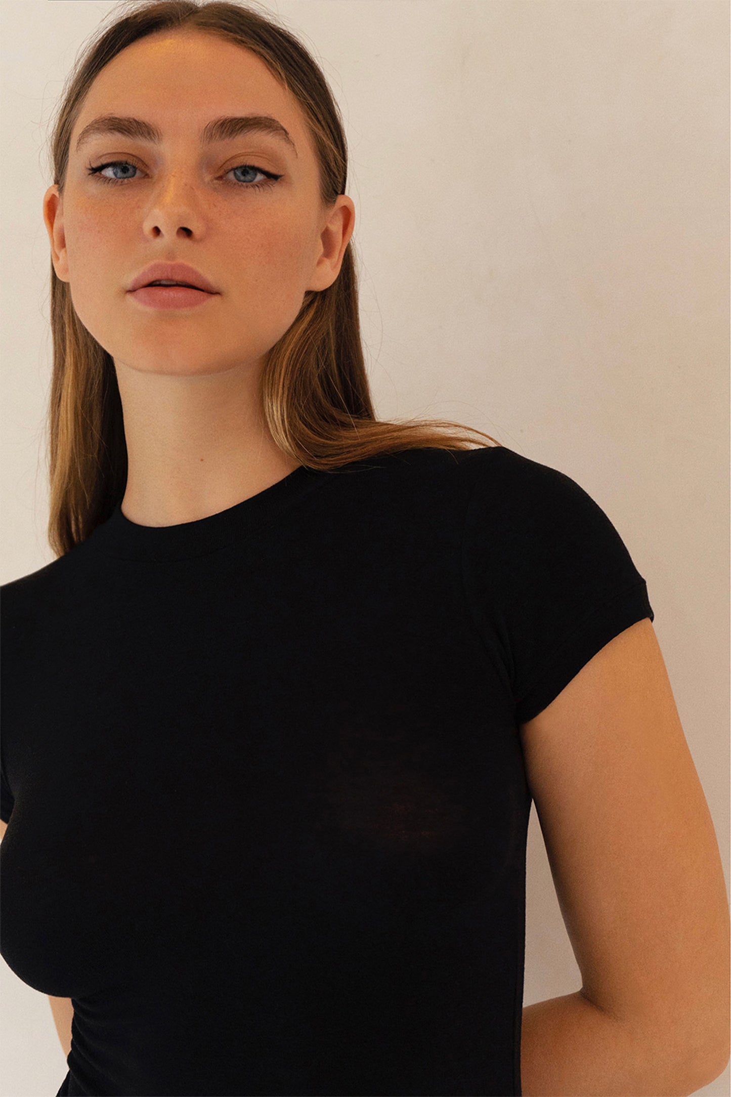 Close-up of model wearing Aurelia Raw Paris black short sleeve top with subtle sheer detail