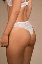 Side-back angle of Aurelia Raw lace thong showcasing sheer mesh design and elegant floral embroidery