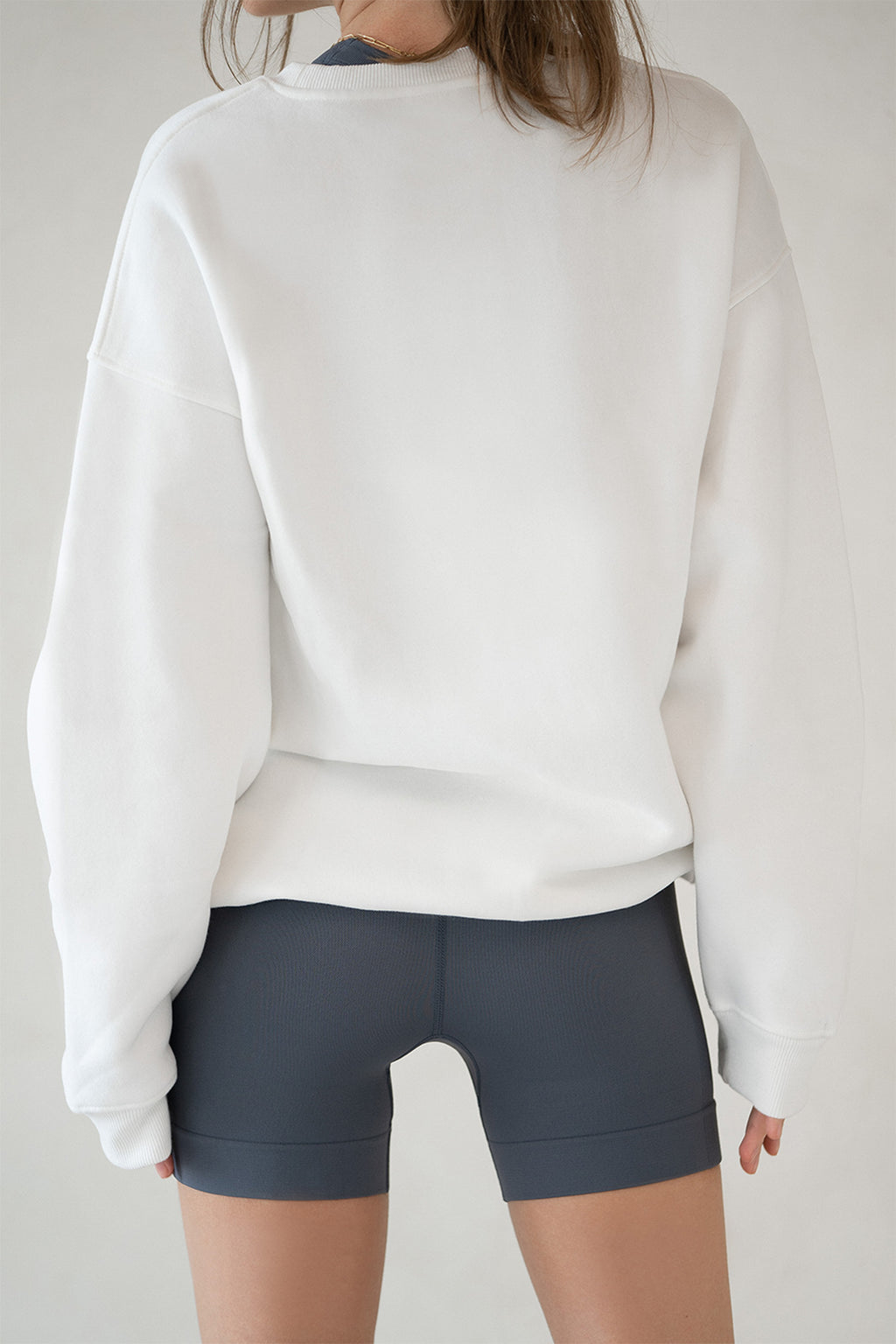 Model in Aurelia Raw Layover Pullover from behind with hands relaxed and fleece texture visible