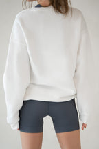 Model in Aurelia Raw Layover Pullover from behind with hands relaxed and fleece texture visible