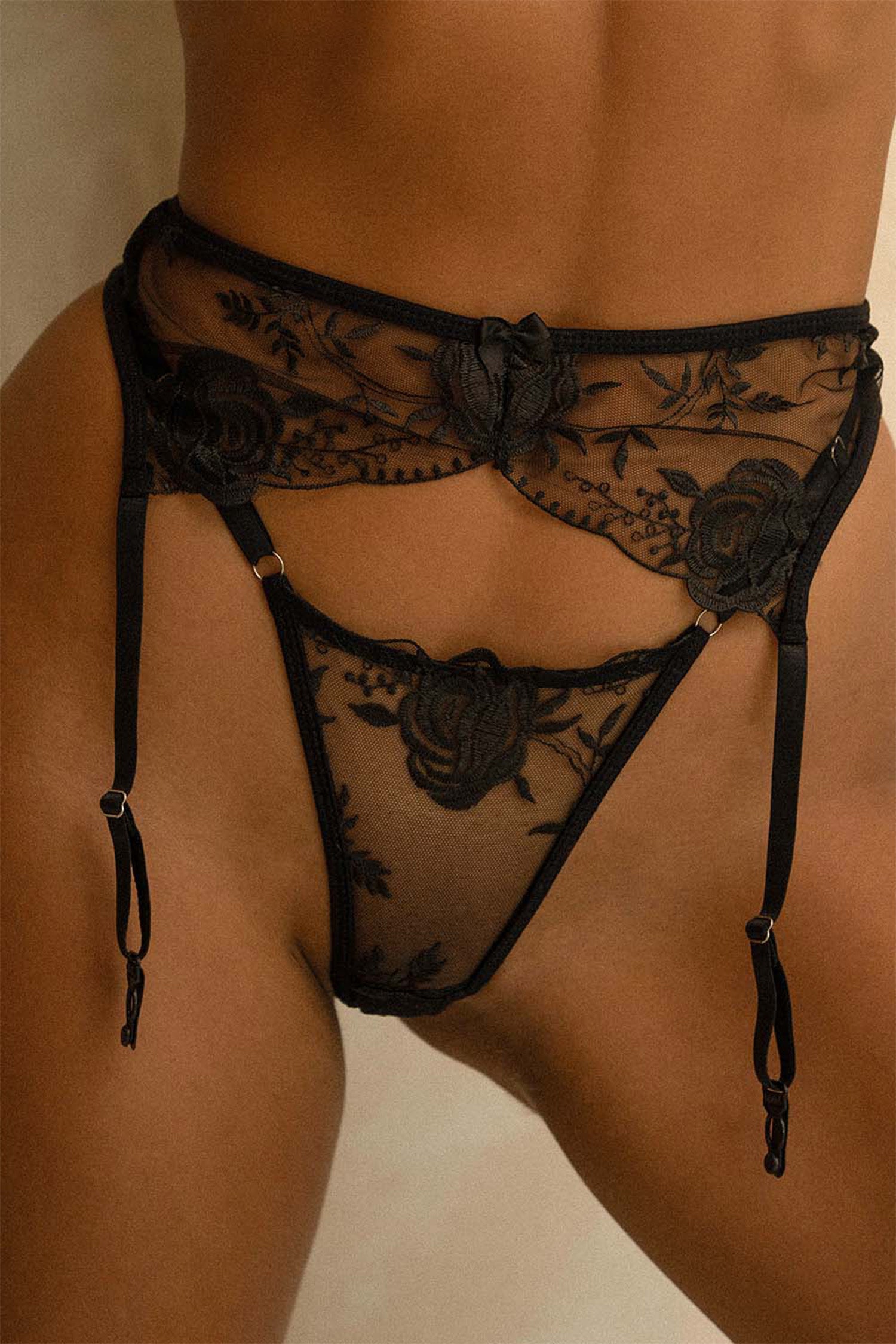 Close-up of Venice garter belt and thong from Aurelia Raw, featuring sheer black lace with floral embroidery